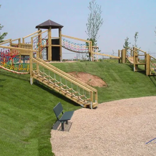 Spielplatz mit Holzspielturm, Hängebrücke und Rutsche