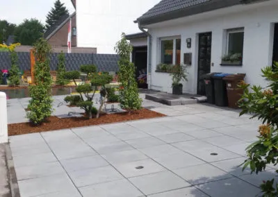 Privatgarten mit Rasenfläche, Hecken und gepflastertem Sitzplatz
