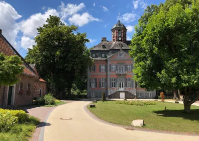 Gepflegte Rasenfläche und Wegeanlage vor historischem Gebäude