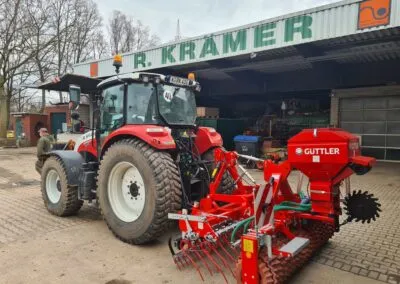 Traktor mit angebauter Sähmaschine in der Halle