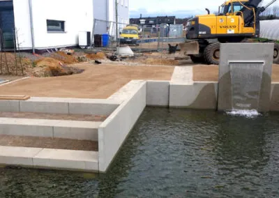Bau einer Wasseranlage mit Beton- und Natursteinarbeiten