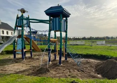 Spielanlage mit Klettergerüst und Turm auf Fallschutzfläche
