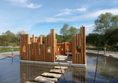 Wasserspielplatz mit Holzspielgeräten und Sandfläche